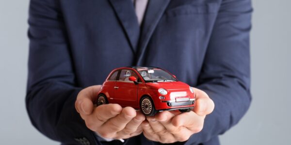 male insurance agent holding toy car on grey backg 2026 03 05 11 45 45 utc